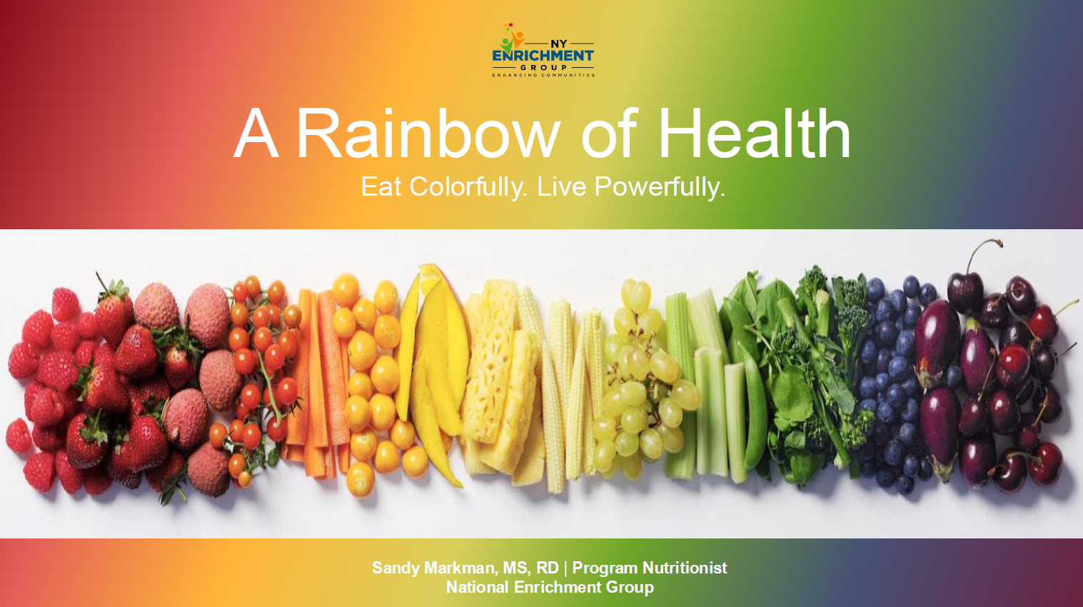 A variety of colorful fruits and vegetables, including strawberries, carrots, corn, bananas, broccoli, blueberries, and cherries, are arranged in a row on a white surface against a rainbow gradient background.